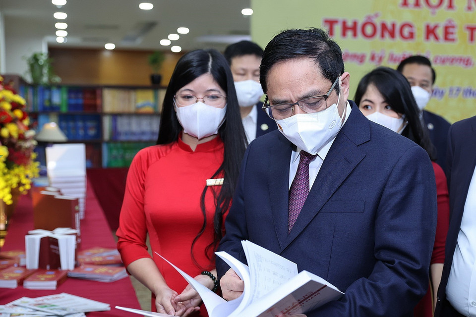  Thủ tướng Phạm Minh Chính xem sách, hình ảnh, hiện vật của ngành thống kê. (Ảnh: Dương Giang/TTXVN)