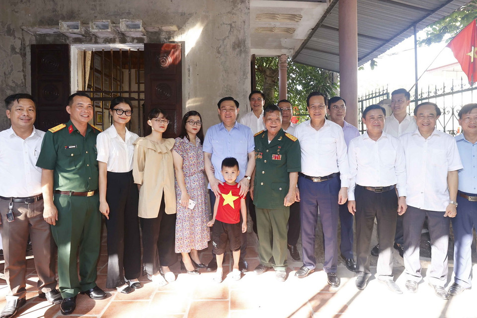 Chủ tịch Quốc hội Vương Đình Huệ chụp ảnh chung cùng gia đình Anh hùng lực lượng Vũ trang, thương binh 3/4 Đoàn Minh Nguyệt. (Ảnh: Doãn Tấn/TTXVN)