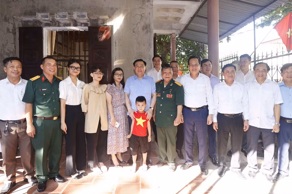 Chủ tịch Quốc hội Vương Đình Huệ chụp ảnh chung cùng gia đình Anh hùng lực lượng Vũ trang, thương binh 3/4 Đoàn Minh Nguyệt. (Ảnh: Doãn Tấn/TTXVN)