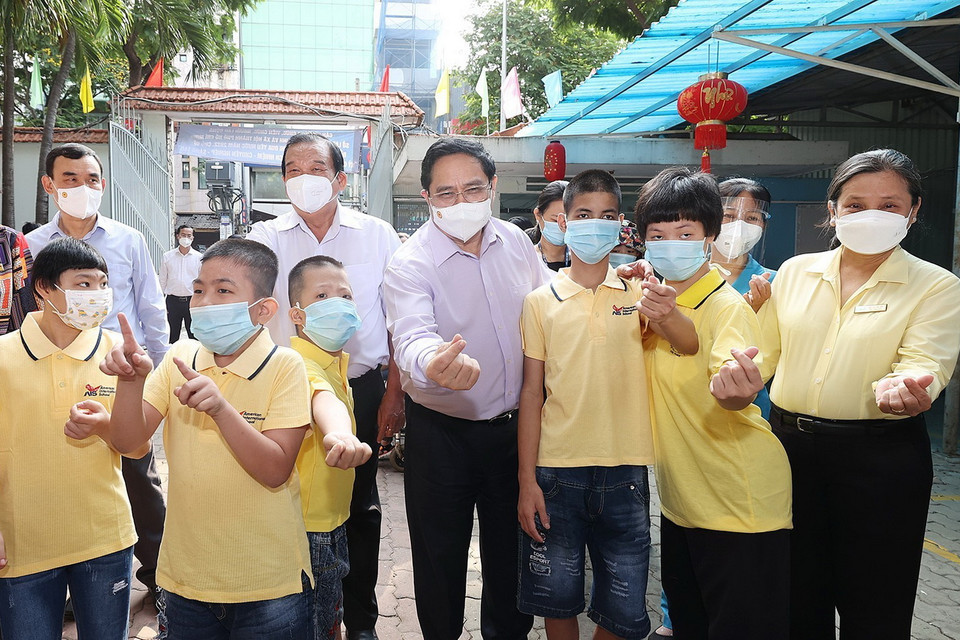  Thủ tướng thăm trẻ em đang được chăm sóc tại Trung tâm bảo trợ trẻ tàn tật mồ côi Thị Nghè. (Ảnh: Dương Giang/TTXVN)