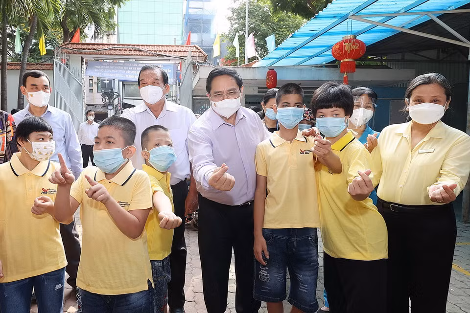  Thủ tướng thăm trẻ em đang được chăm sóc tại Trung tâm bảo trợ trẻ tàn tật mồ côi Thị Nghè. (Ảnh: Dương Giang/TTXVN)