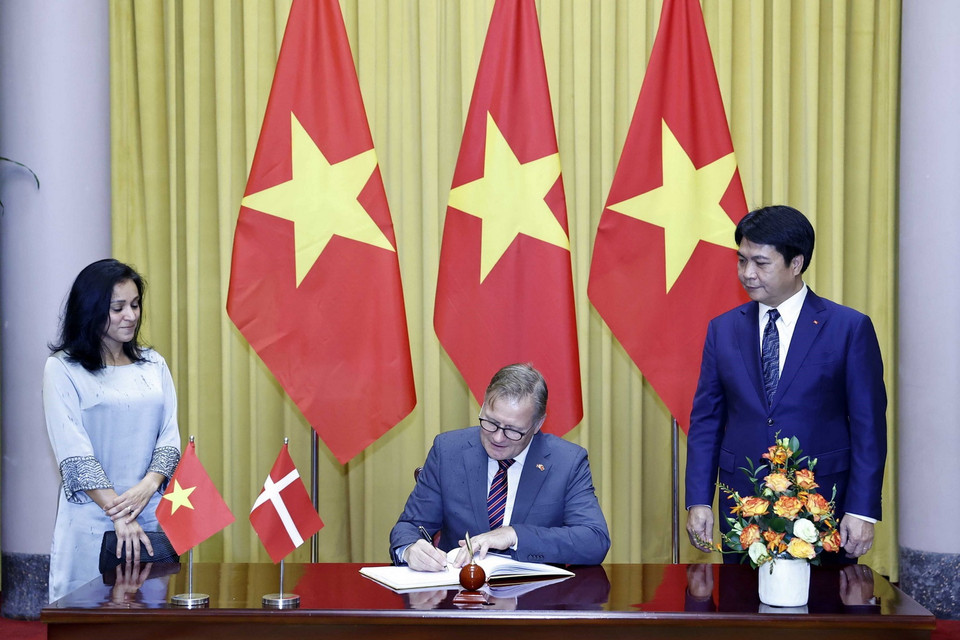 Đại sứ Vương quốc Đan Mạch Nicolai Prytz viết lưu bút. (Ảnh: Thống Nhất/TTXVN)