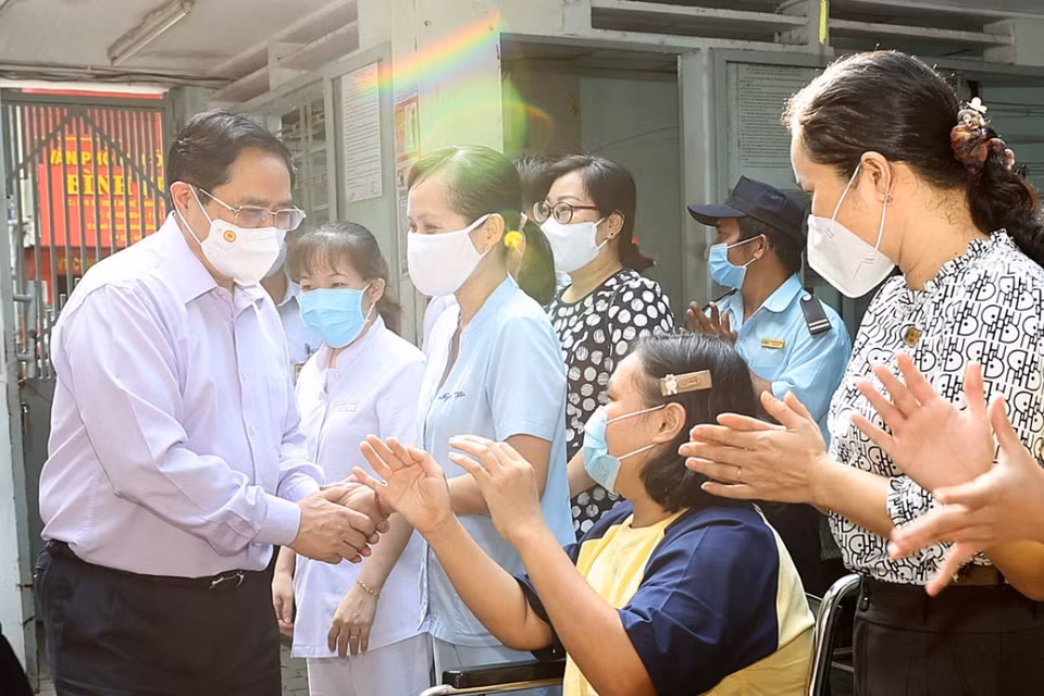  Thủ tướng Phạm Minh Chính cùng cán bộ, nhân viên và trẻ em đang được nuôi dưỡng, chăm sóc tại Trung tâm Bảo trợ trẻ tàn tật mồ côi Thị Nghè. (Ảnh: Dương Giang/TTXVN)