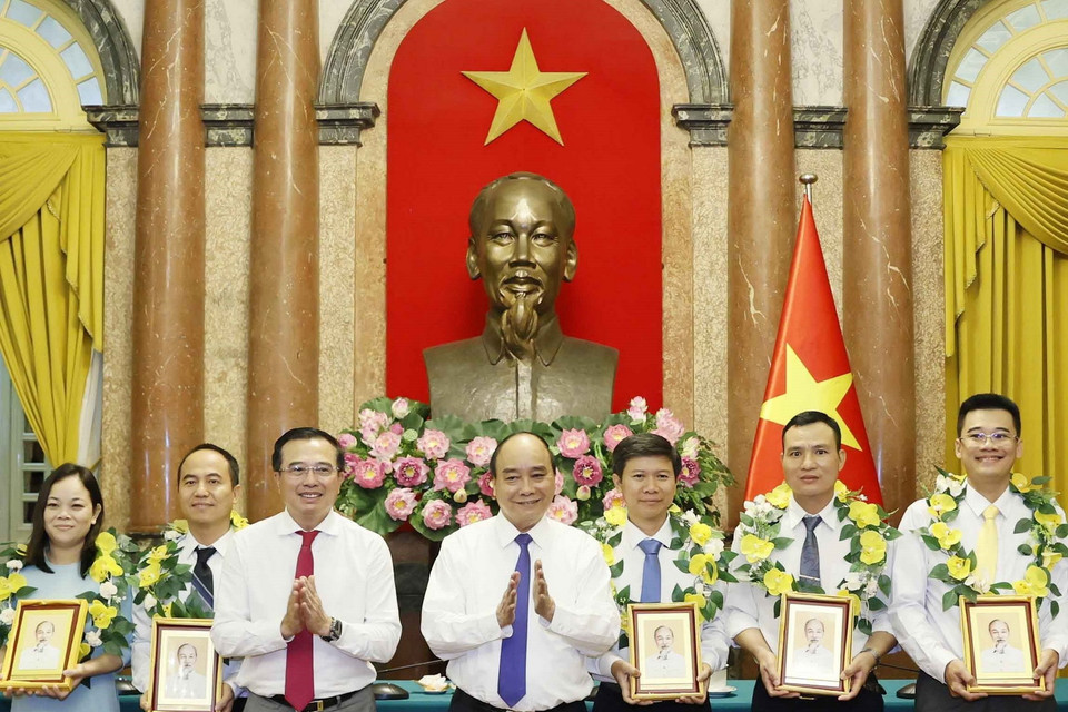 Chủ tịch nước tặng chân dung Chủ tịch Hồ Chí Minh cho cán bộ, công nhân lao động tiêu biểu ngành Dầu khí. (Ảnh: Thống Nhất/TTXVN)