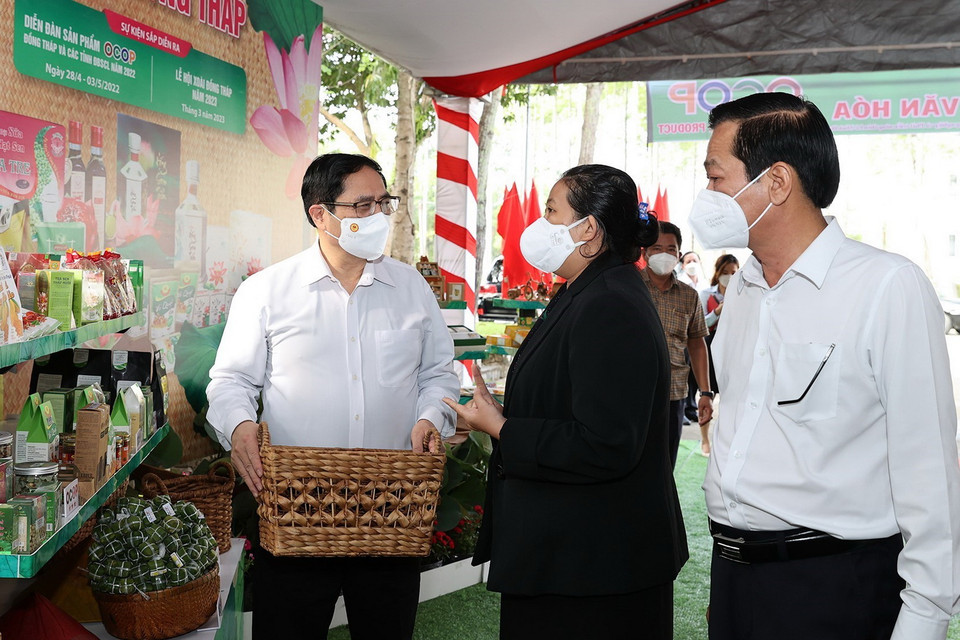  Thủ tướng Phạm Minh Chính trao đổi về các sản phẩm nông nghiệp. (Ảnh: Dương Giang/TTXVN)