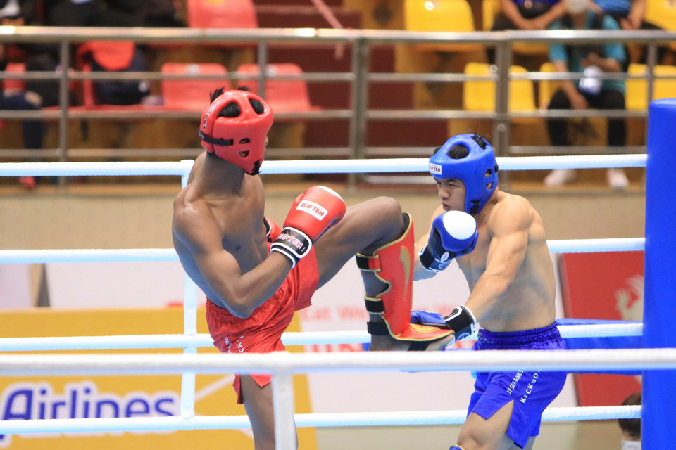 Trận đấu giữa vận động viên Chhoeung Lvay của đội Campuchia (đỏ) và vận động viên Nazri-Bin-Sutari Muhammad của đội Singapore (xanh) ở nội dung Low Kick, hạng cân dưới 71kg với tỷ số 3-0. (Ảnh: Thanh Thương/TTXVN)