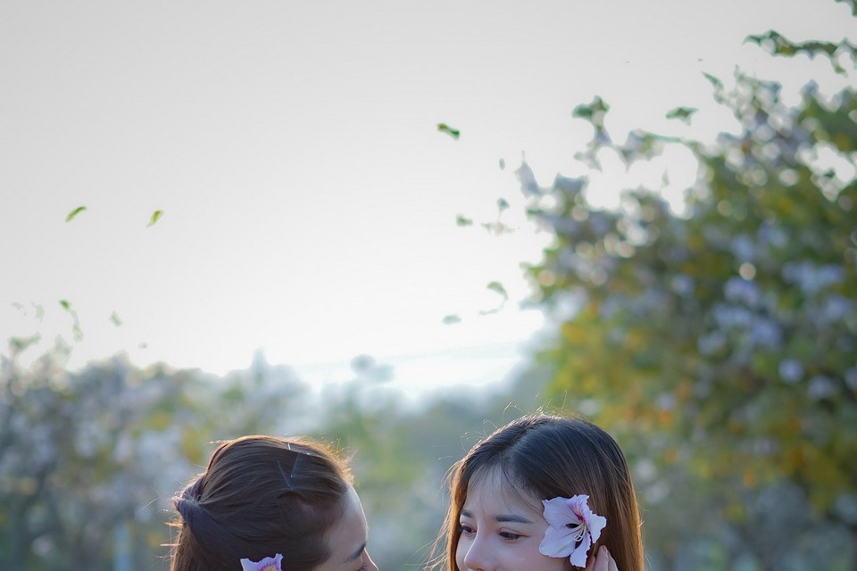 Thiếu nữ trong bộ áo cóm dân tộc Thái tạo dáng với hoa ban. (Ảnh: Xuân Tư/TTXVN)