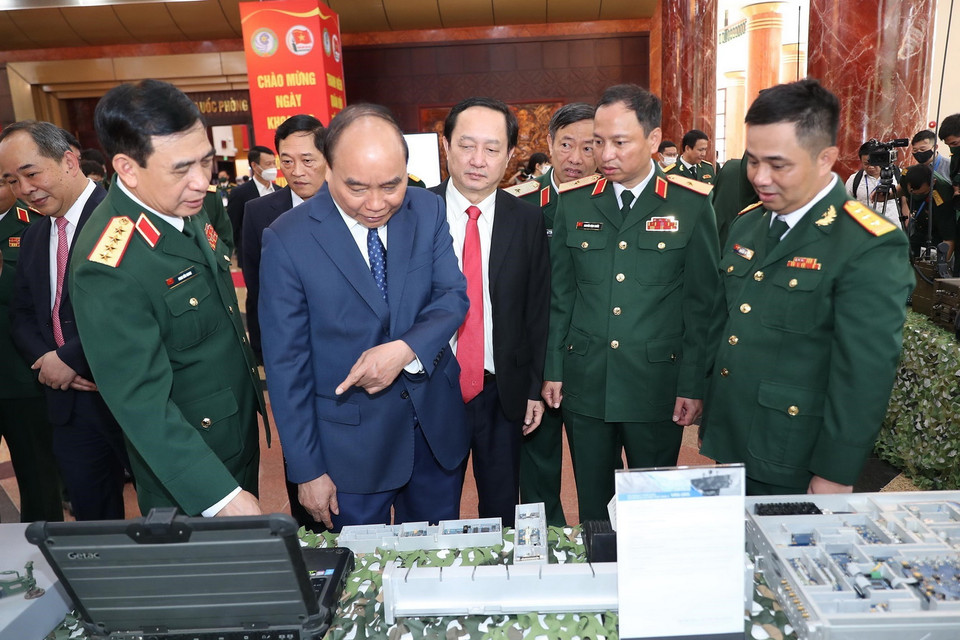 Chủ tịch nước Nguyễn Xuân Phúc và các đại biểu tham quan trưng bày sản phẩm khoa học, công nghệ lĩnh vực quân sự, quốc phòng. (Ảnh: Trọng Đức/TTXVN)