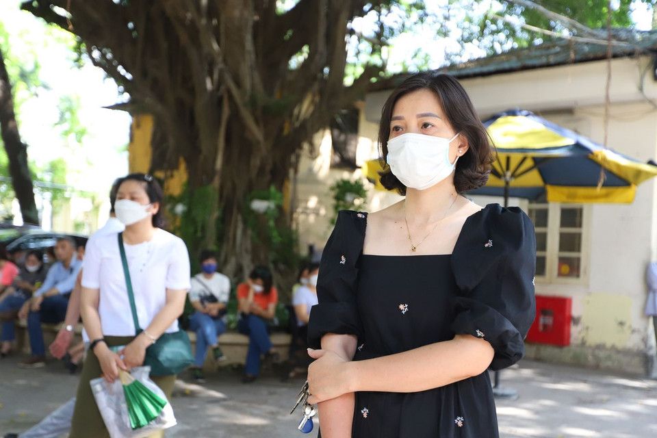 Chị Phạm Ngọc Dung (Kim Ngưu, quận Hai Bà Trưng) đứng nán lại đợi con phía bên ngoài trường. Chị cho biết: “Tôi có dặn con vào phòng thi phải luôn bình tĩnh, không hồi hộp nhưng tôi đứng bên ngoài lại cảm thấy rất lo lắng,” chị Dung cho hay. (Ảnh: PV/Vietnam+)