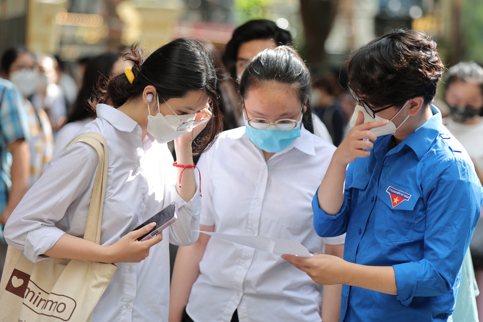 Tình nguyên viên hướng dẫn thi sinh trước khi vào điểm thi. (Ảnh: PV/Vietnam+) 