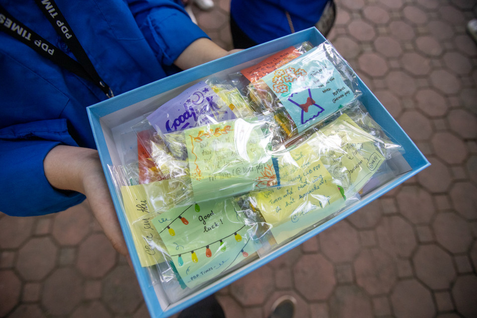 Các tình nguyện viên gửi 'gói lời chúc' tới các sỹ tử. (Ảnh: PV/Vietnam+)