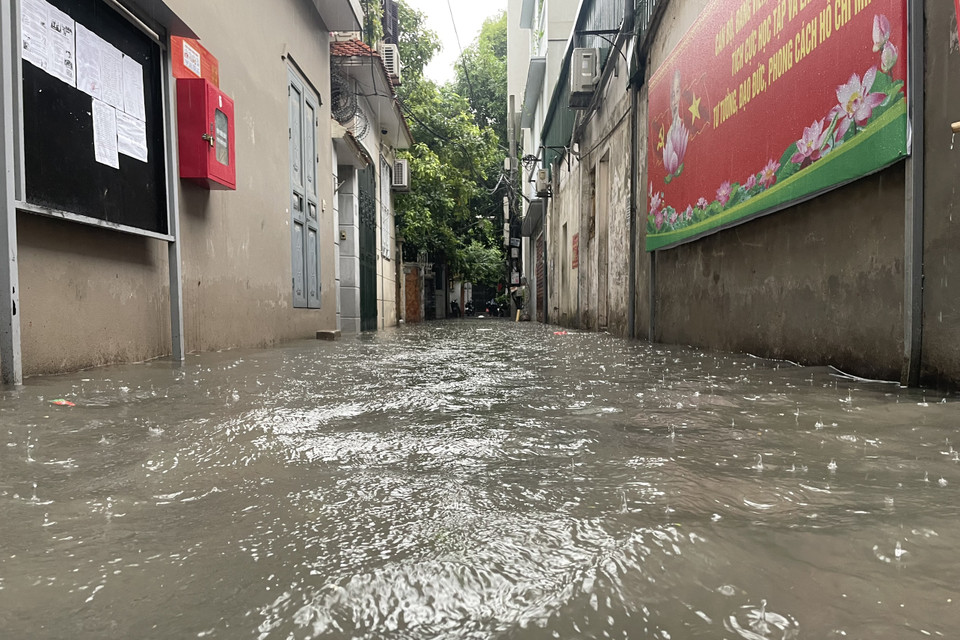 Mưa ngập tràn vào các con ngõ tại Thủ đô. (Ảnh: Minh Hiếu/Vietnam+)
