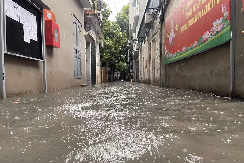 Mưa ngập tràn vào các con ngõ tại Thủ đô. (Ảnh: Minh Hiếu/Vietnam+)