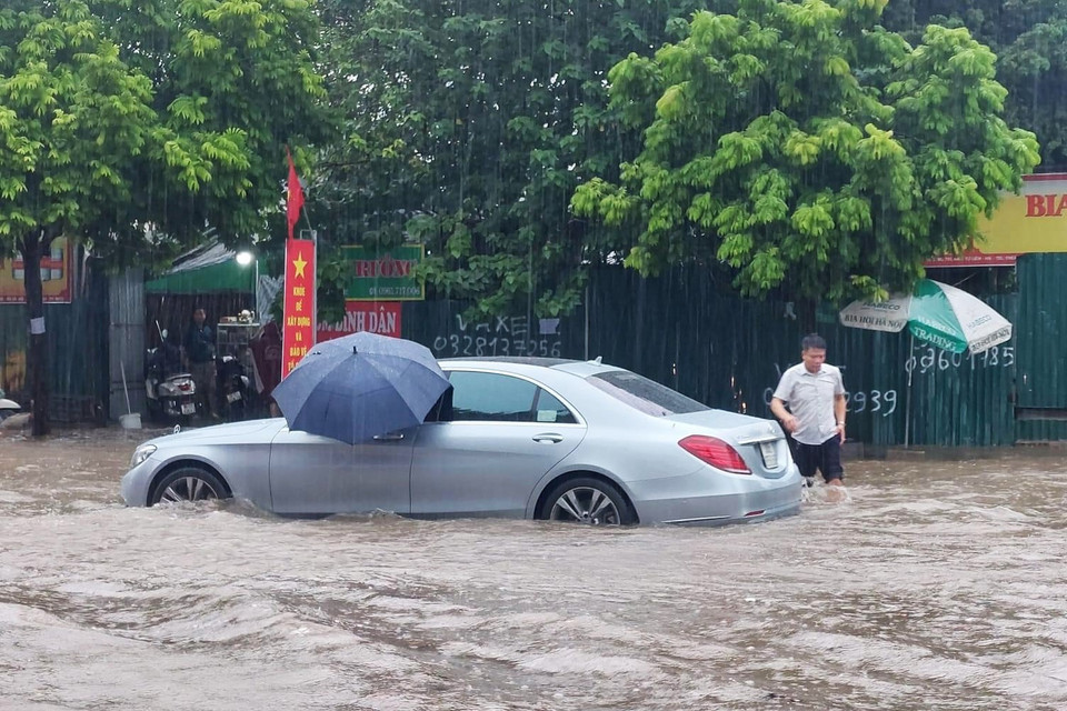 Phương tiện ôtô cũng bị chết máy, không thể đi qua đoạn ngập nặng. (Ảnh: PV/Vietnam+)