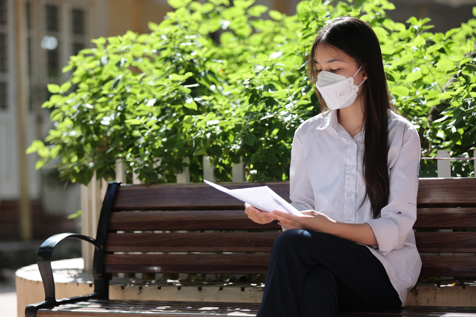 Thí sinh ngồi kiểm tra thông tin cá nhân trước khi vào phòng thi để làm thủ tục đăng ký. (Ảnh: PV/Vietnam+)