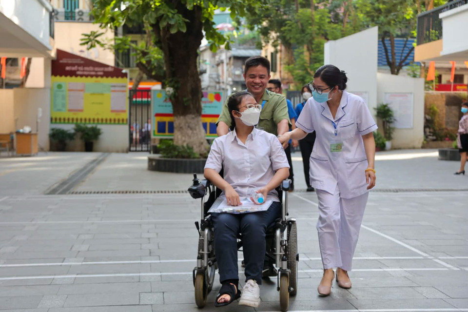 Tại điểm thi này có thí sinh bị gãy chân được nhân viên y tế và cán bộ tại điểm thi đưa vào phòng thi. (Ảnh: PV/Vietnam+) 