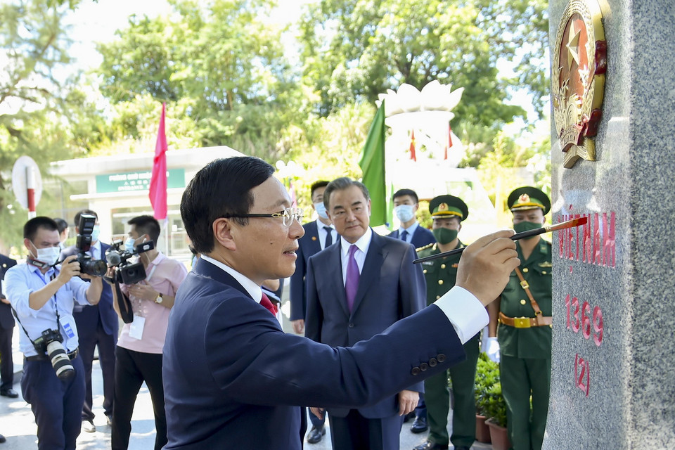Phó Thủ tướng, Bộ trưởng Ngoại giao Phạm Bình Minh tô sơn lên cột mốc 1369 Việt Nam dưới sự chứng kiến của Bộ trưởng Ngoại giao Vương Nghị. (Ảnh: TTXVN)