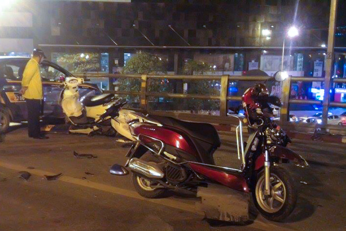 Khoảng 22h40 phút ngày 8/10, chiếc taxi của hãng Vinataxi di chuyển trên cầu vượt nút giao thông Chùa Bộc - Thái Hà bất ngờ mất lái và tông trực diện hàng chục xe máy đang lưu thông. (Ảnh: Minh Sơn/Vietnam+)