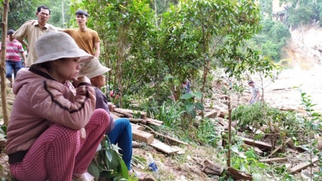 Người dân trong khu sạt lở Trà Leng ngồi chờ thông tin từ lực lượng tìm kiếm. (Ảnh: Trần Lê Lâm/TTXVN)