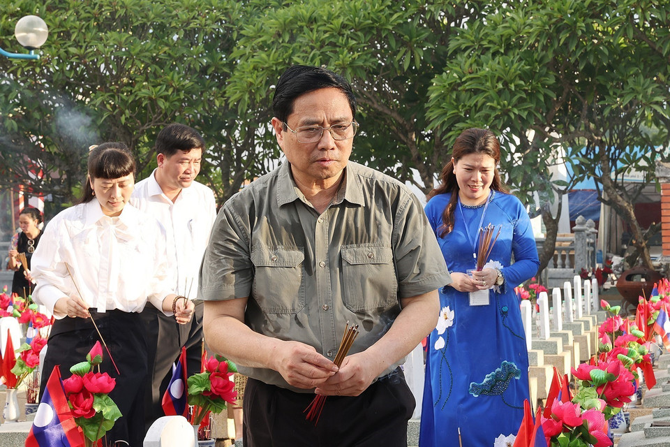 Thủ tướng Phạm Minh Chính thắp hương trên phần mộ liệt sỹ tại Nghĩa trang liệt sỹ quốc tế Việt - Lào. (Ảnh: Dương Giang/TTXVN)