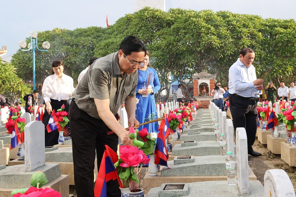 Thủ tướng Phạm Minh Chính thắp hương phần mộ liệt sỹ tại Nghĩa trang quốc tế Việt-Lào. (Ảnh: Dương Giang/TTXVN)