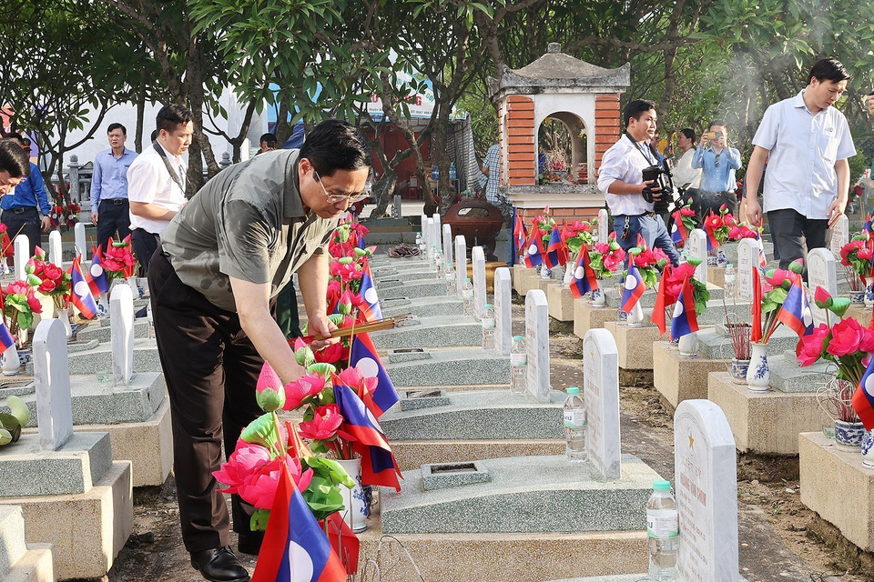 Thủ tướng Phạm Minh Chính thắp hương phần mộ liệt sỹ tại Nghĩa trang quốc tế Việt-Lào. (Ảnh: Dương Giang/TTXVN)