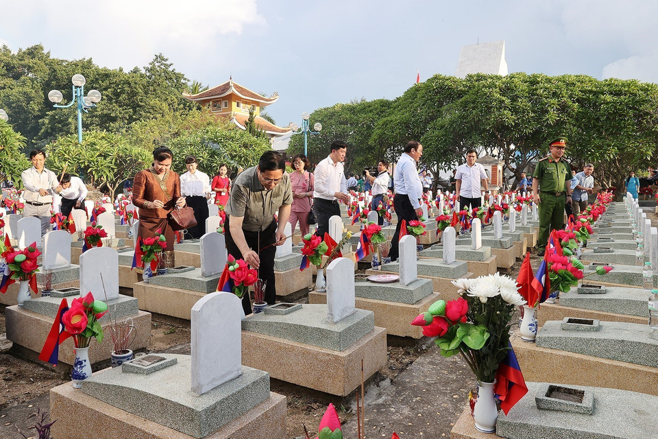 Thủ tướng Phạm Minh Chính thắp hương trên phần mộ liệt sỹ tại Nghĩa trang liệt sỹ quốc tế Việt - Lào. (Ảnh: Dương Giang/TTXVN)