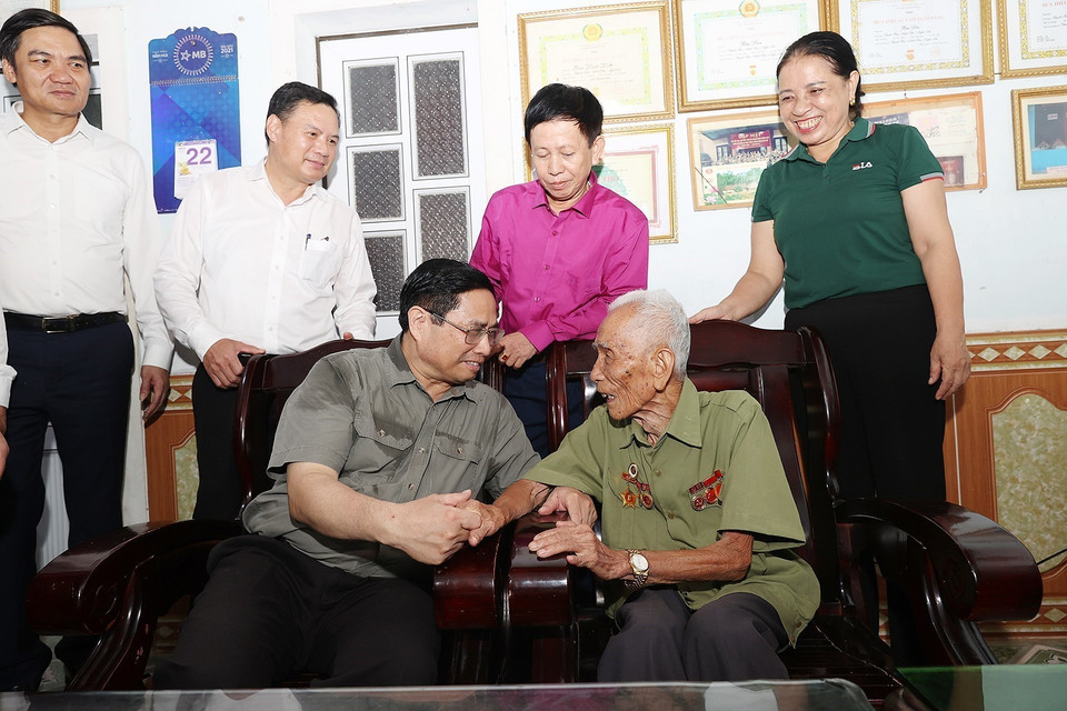 Thủ tướng Phạm Minh Chính thăm ông Bùi Đôn, cán bộ đảng viên 75 năm tuổi Đảng ở xã Thạch Sơn, huyện Anh Sơn. (Ảnh: Dương Giang/TTXVN)