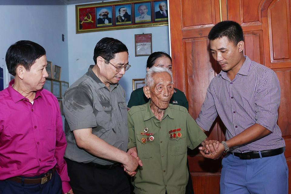 Thủ tướng Phạm Minh Chính thăm ông Bùi Đôn, cán bộ đảng viên 75 năm tuổi Đảng ở xã Thạch Sơn, huyện Anh Sơn. (Ảnh: Dương Giang/TTXVN)