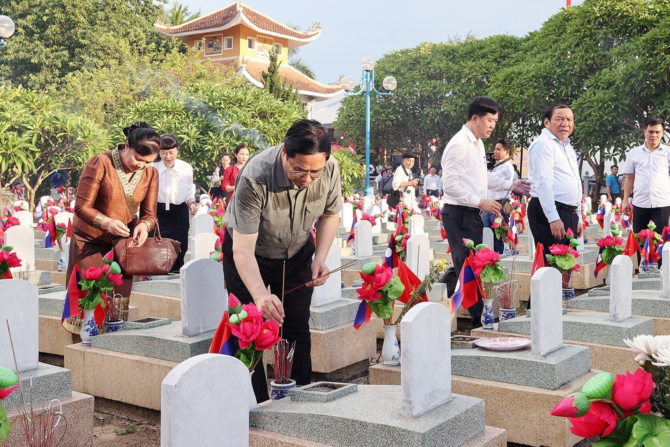 Thủ tướng Phạm Minh Chính thắp hương phần mộ liệt sỹ tại Nghĩa trang quốc tế Việt-Lào. (Ảnh: Dương Giang/TTXVN)