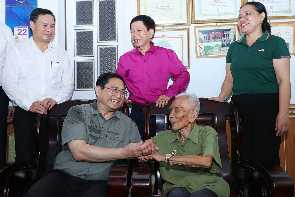 Thủ tướng Phạm Minh Chính thăm ông Bùi Đôn, cán bộ đảng viên 75 năm tuổi Đảng ở xã Thạch Sơn, huyện Anh Sơn. (Ảnh: Dương Giang/TTXVN)