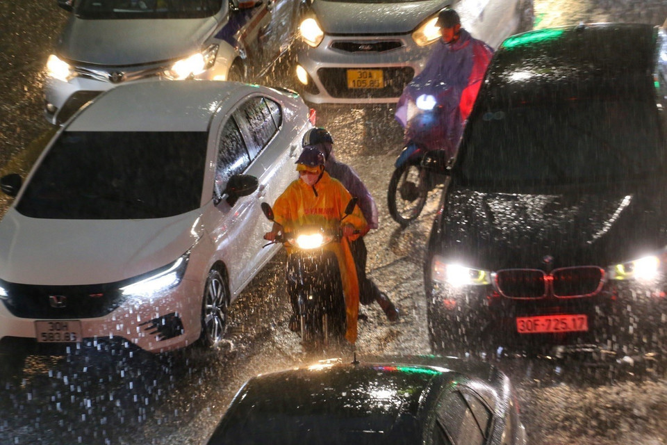 Xe máy len lỏi giữa "rừng" ô tô, phố Tây Sơn ùn tắc trong trời mưa lớn. (Ảnh: Tuấn Đức/TTXVN)