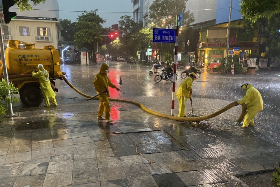 Công nhân Công ty Thoát nước Hà Nội triển khai các biện pháp chống ngập tại ngã 5 Bà Triệu - Nguyễn Du - Hồ Xuân Hương. (Ảnh: Mạnh Khánh/TTXVN)