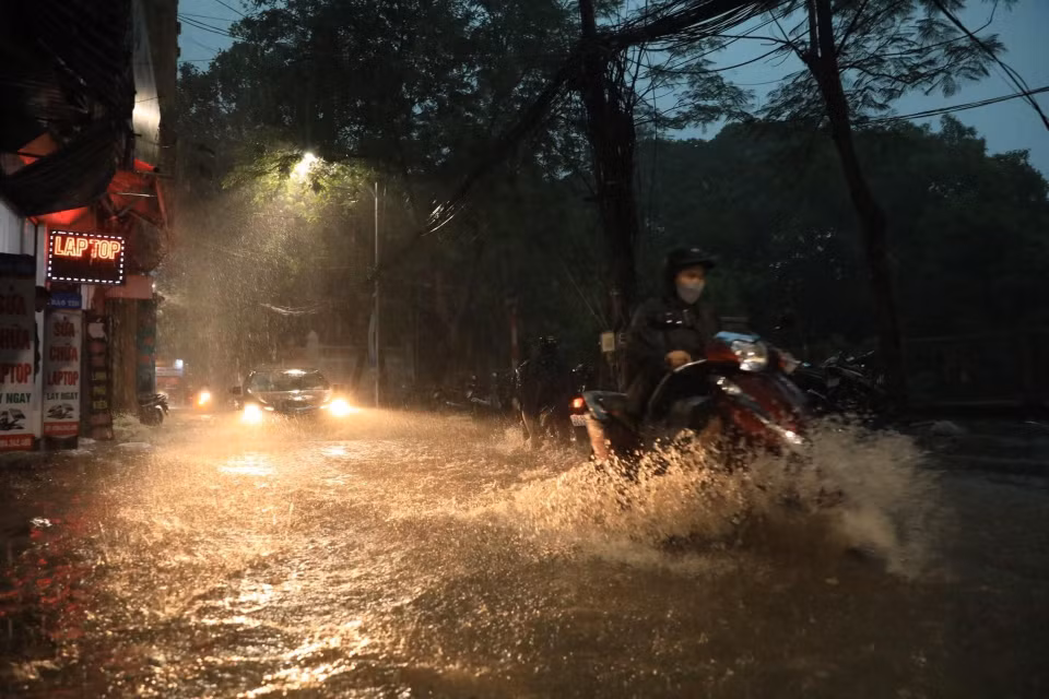 Phố Khương Hạ ngập khiến nhiều người đi lại khó khăn. (Ảnh: Tuấn Anh/TTXVN)