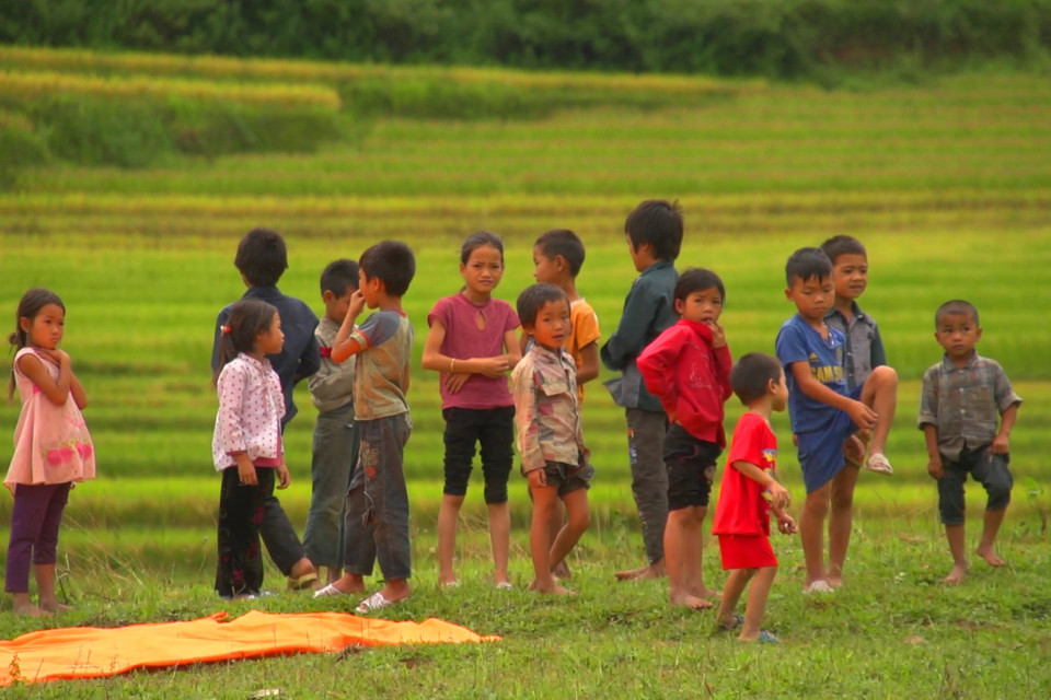 Trẻ em chờ đón phi công ở bãi đáp dưới chân đèo Khau Phạ... (Ảnh: Tùng Lâm/Vietnam+)