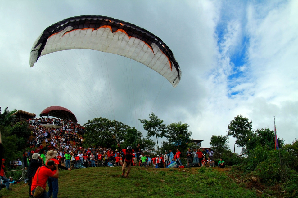 Hồi hộp chờ đến ngày thứ hai của lễ hội dù lượn, trời hết mưa và gió êm hơn, các phi công mới có thể cất cánh. (Ảnh: Xuân Mai/Vietnam+)