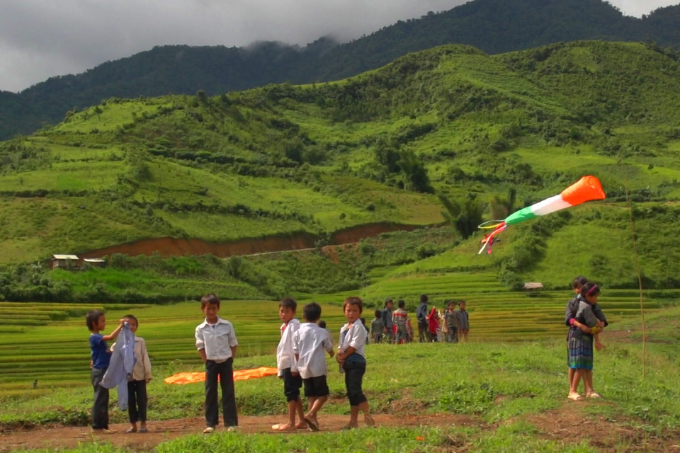 Đội nắng, đội gió và có lúc đội cả mưa nhưng vẫn háo hức chờ một cánh diều bổ bộ. (Ảnh: Tùng Lâm/Vietnam+)