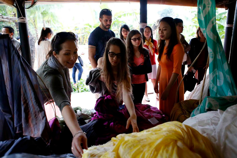 Khách tham quan, tìm hiểu về sản phẩm tơ lụa của các làng nghề lụa Việt Nam. (Nguồn: Trần Lê Lâm/Vietnam+)