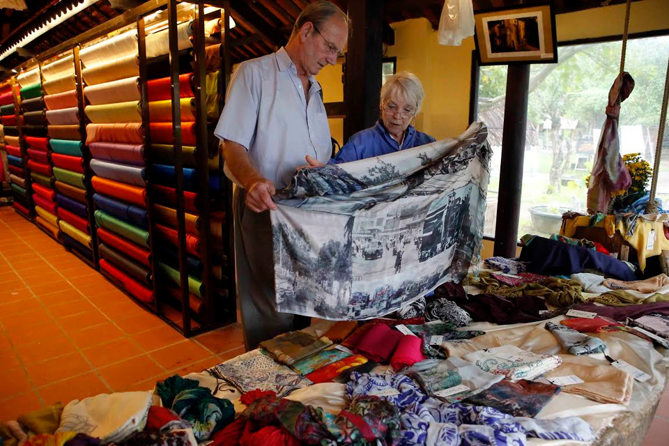 Khách nước ngoài tham quan tìm mua sản phẩm lụa nổi tiếng của các làng nghề lụa Việt Nam. (Nguồn: Trần Lê Lâm/Vietnam+)