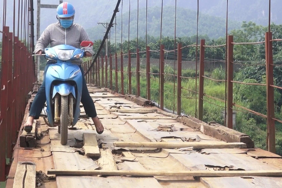 Người dân lưu thông khó khăn trên cầu treo xuống cấp. (Ảnh: Thanh Hải/TTXVN)