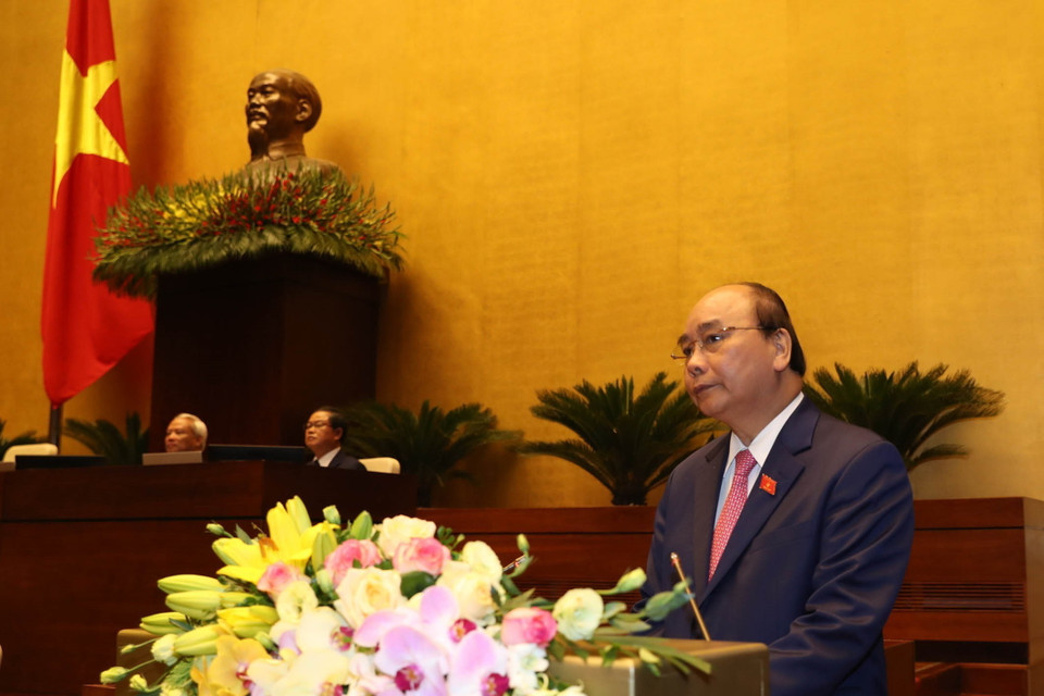 Thủ tướng Nguyễn Xuân Phúc đọc báo cáo của Chính phủ. (Ảnh: Trọng Đức/TTXVN)