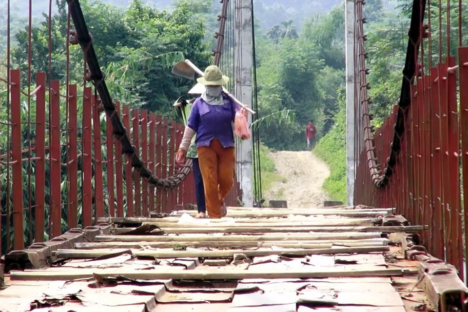 Người dân lưu thông khó khăn trên cầu treo xuống cấp. (Ảnh: Thanh Hải/TTXVN)