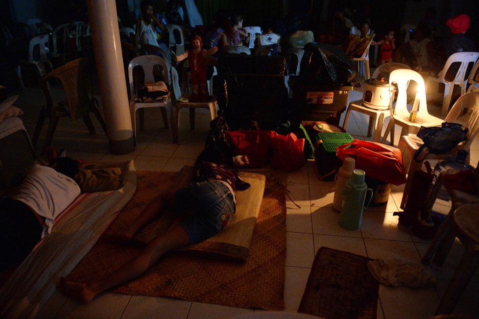 Người dân trú tránh bão trong một tu viện dước ánh sáng của những ngọn nến tại thành phố Legazpi.