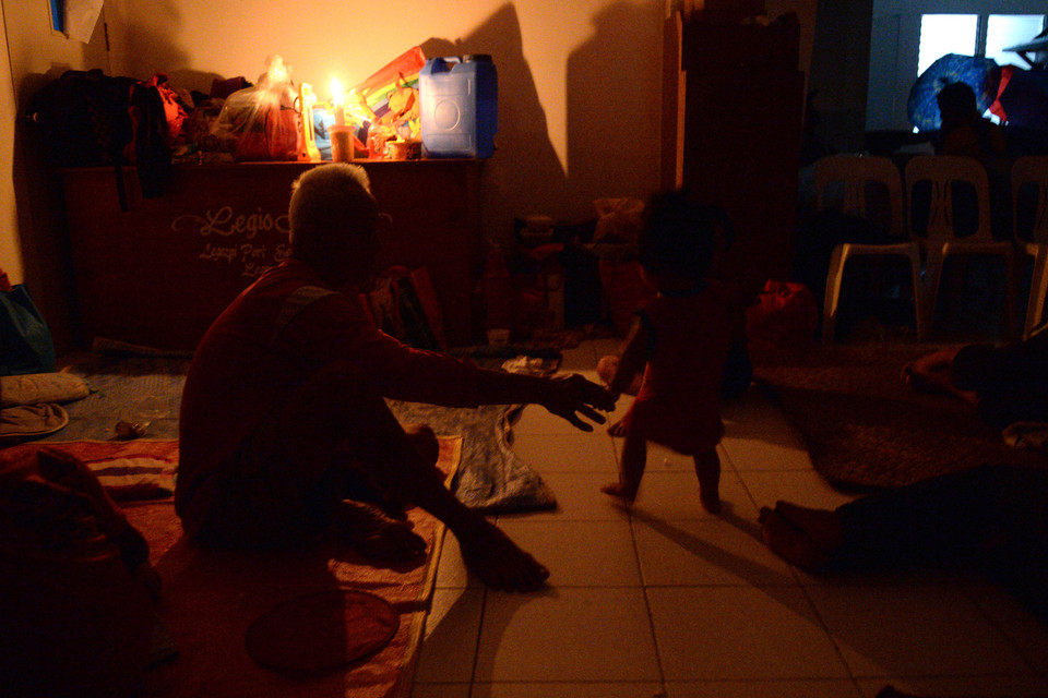  Người dân trú tránh bão trong một tu viện dước ánh sáng của những ngọn nến tại thành phố Legazpi.