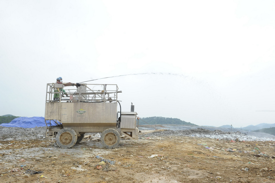  Công ty TNHH MTV Môi trường Đô thị Hà Nội phun chế phẩm Posi-shell nhằm khử mùi, chống rác bay, ngăn nước mưa lẫn vào nước. (Ảnh: Mạnh Khánh/TTXVN)