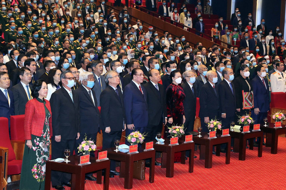 Các vị lãnh đạo, nguyên lãnh đạo Đảng, Nhà nước và đại biểu thực hiện nghi lễ chào cờ. (Ảnh: Thống Nhất/TTXVN)