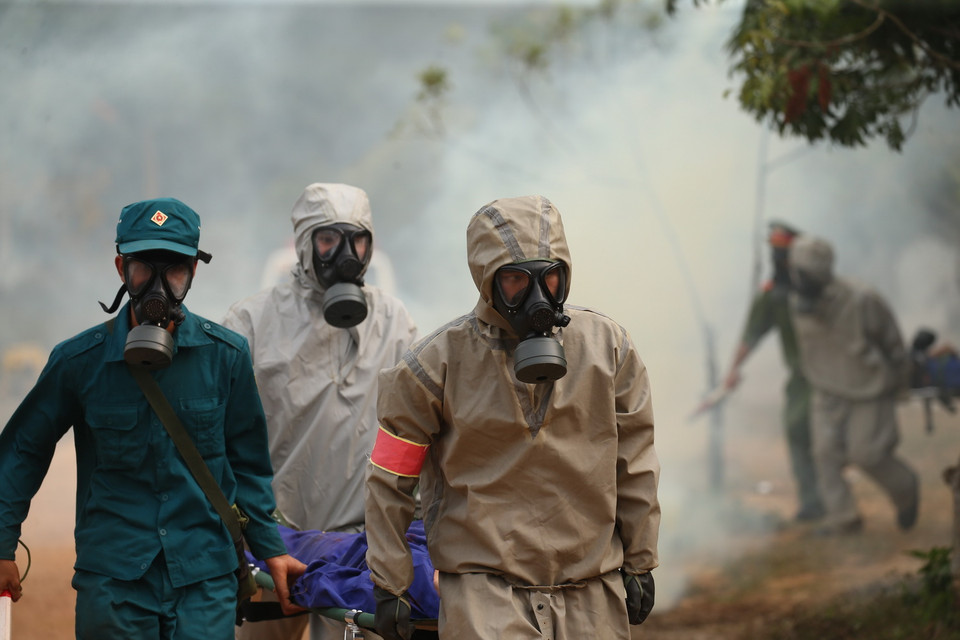  Lực lượng Bộ đội hóa học và lực lượng cứu nạn tại Hà Nội chỗ đưa người bị nạn rời hiện trường. (Ảnh: Dương Giang/TTXVN)