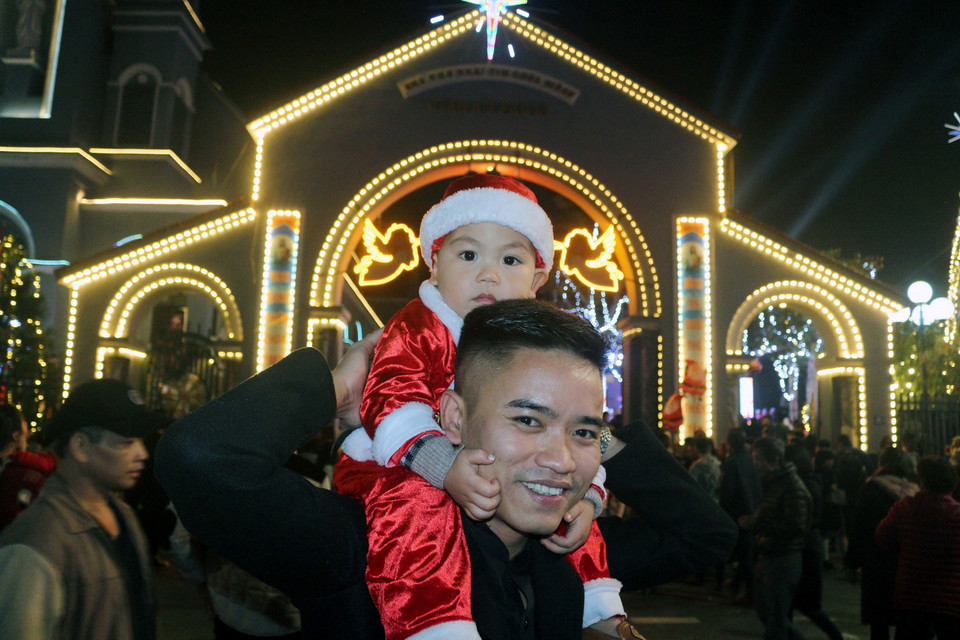 Người dân tranh thủ lưu lại những bức ảnh đêm Giáng sinh tại Nhà thờ Phủ Lý, Hà Nam. (Ảnh: Đại Nghĩa/TTXVN)