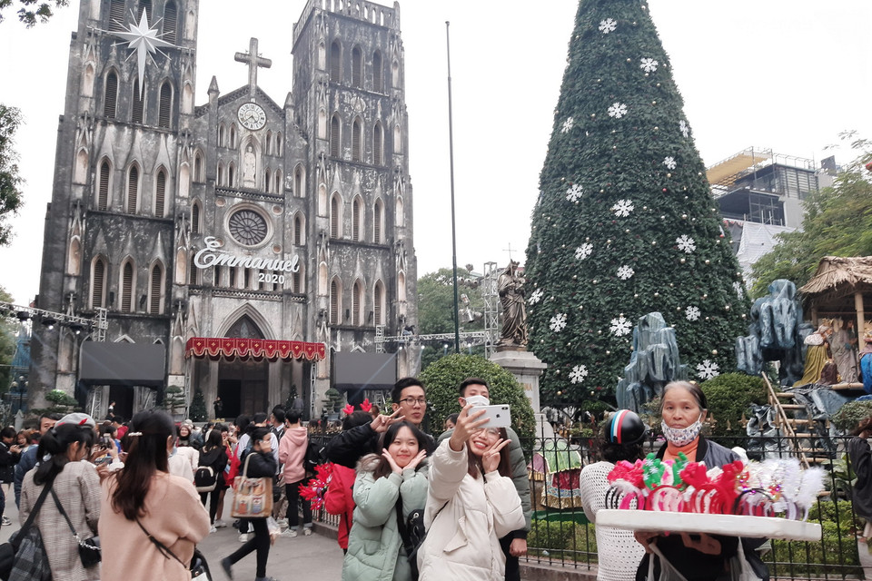 Người dân nô nức đến chụp ảnh vui chơi tại Nhà Thờ Lớn, Hà Nội. (Ảnh: Phương Anh/TTXVN)