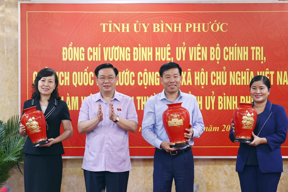 Chủ tịch Quốc hội Vương Đình Huệ tặng vật phẩm lưu niệm cho các cán bộ trong Ban Thường vụ Tỉnh ủy Bình Phước. (Ảnh: Doãn Tấn/TTXVN)